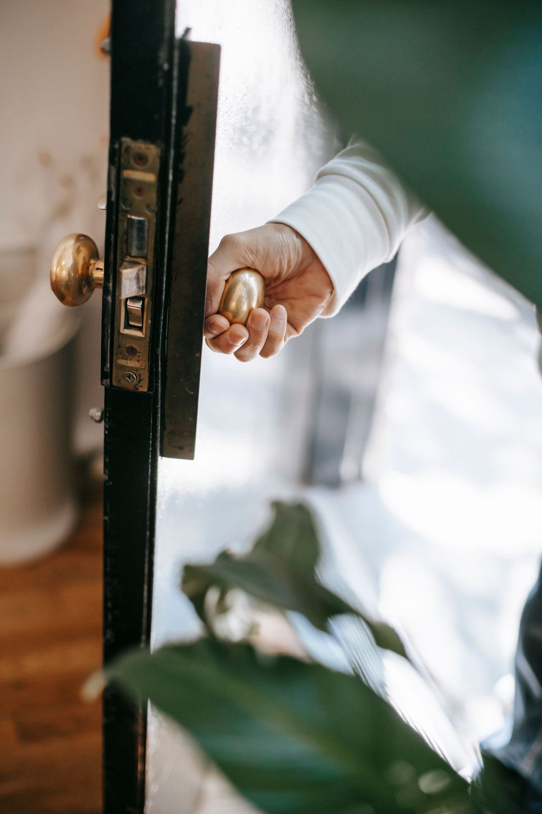 Main tenant une clé devant une serrure de porte